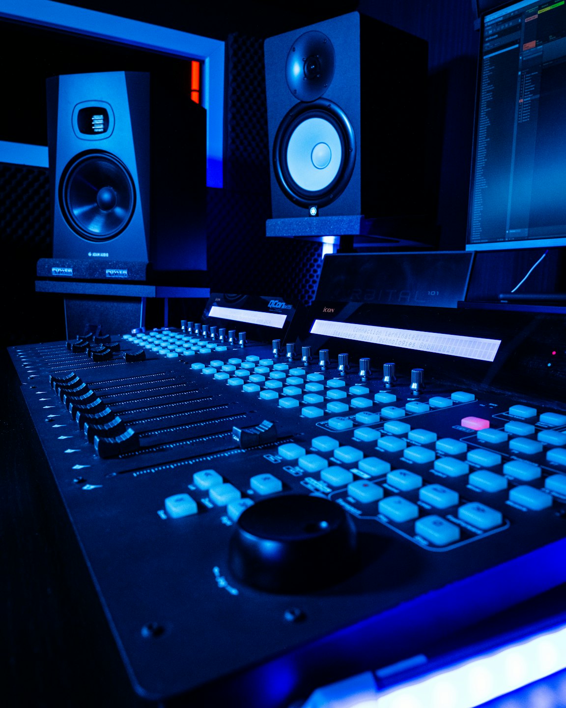 Professionelles Mischpult und Studio-Monitore in einem Musikstudio.